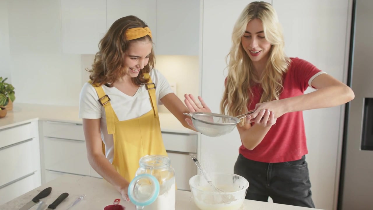 Video vertikal: Dua wanita memasak di dapur, menuangkan tepung dan menyebabkan label menghalangi pandangan