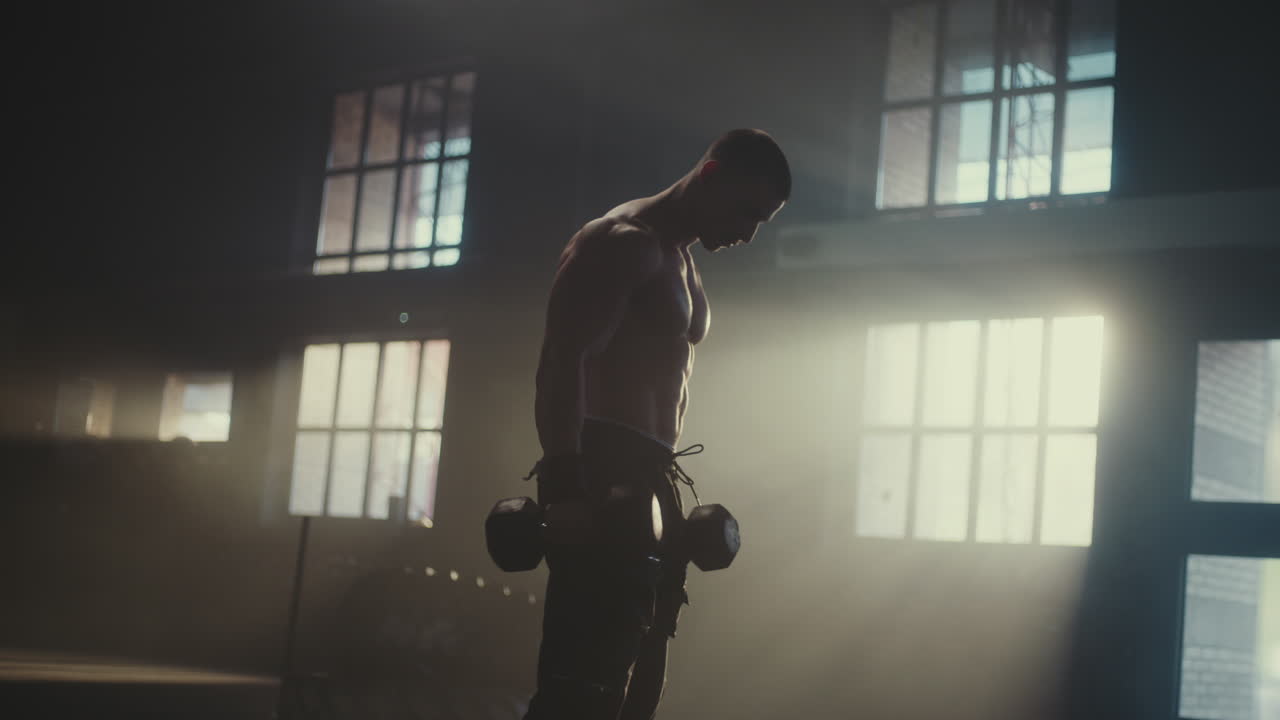 Uomo che esegue curl bicipiti con manubri in palestra