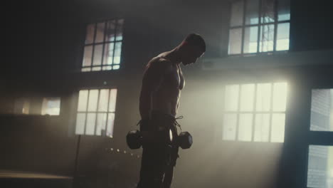 man doing dumbbell bicep curls in gym