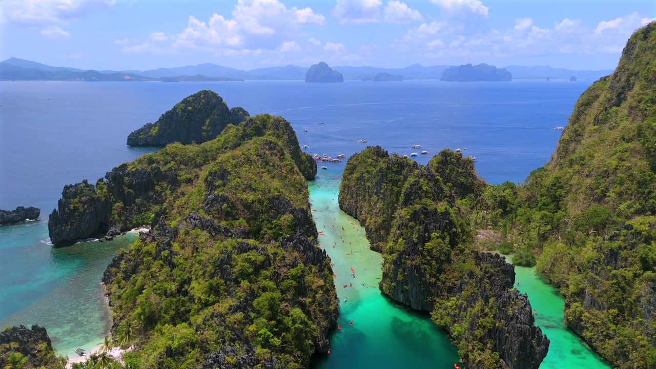 Vista aerea di kayak e barche che si muovono attraverso una laguna turchese di El Nido.