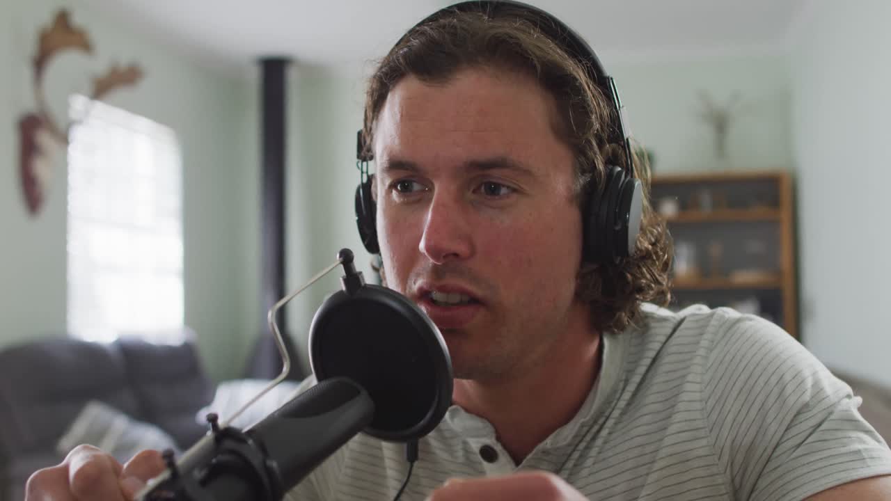 hombre caucásico enfocado con auriculares, hablando y grabando