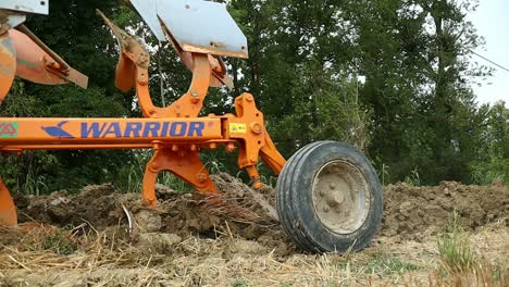 heavy loader tractor towing multiple furrow plow tool