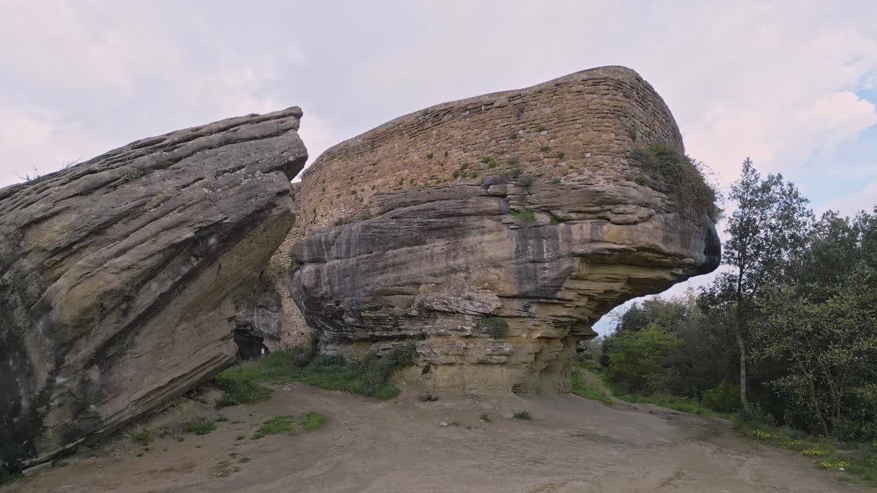 Majestic castle ruins from the eighth century stand proudly on a massive rock formation, a testament to history amidst the serene landscape of taradell, catalonia
