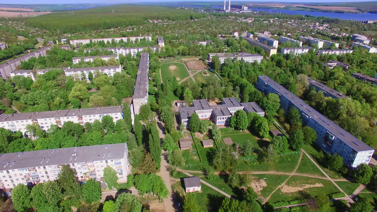 Sunny city drowning in the greenery. Drone footage of Ukrainian city on fantastic sunny day. Aerial perspective.