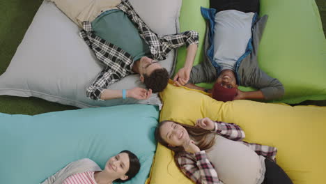 top-view-happy-group-of-business-people-jumping-on-colorful-pillows-resting-together-exhausted-after-working-relaxing-diverse-colleagues-smiling-enjoying-creative-office-workplace