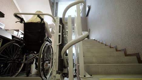 a girl in a wheelchair effortlessly ascends the stairs using a stair lift.