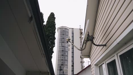 a high-rise building in the city is visible through the roofs of houses. shooting an urban landscape against the sky