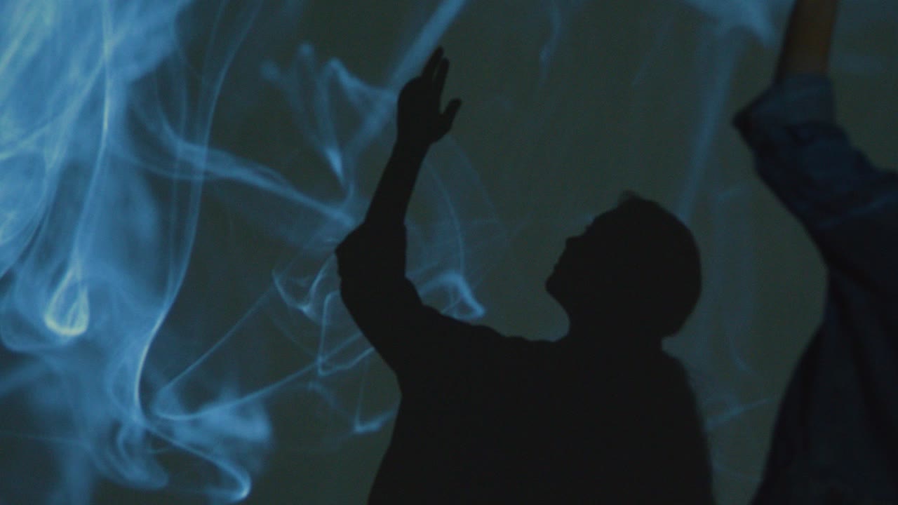 벽 1에 모양과 패턴의 투영과 함께 몰입 예술 전시를 방문하는 여성의 실루