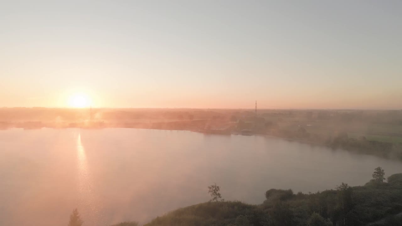 el amanecer brumoso sobre un lago