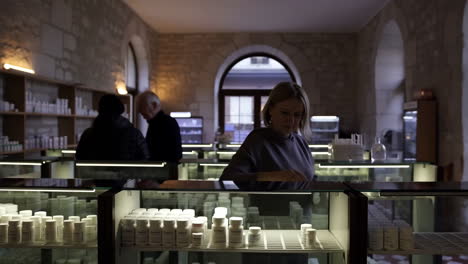 woman arranging products in a traditional pharmacy or store display