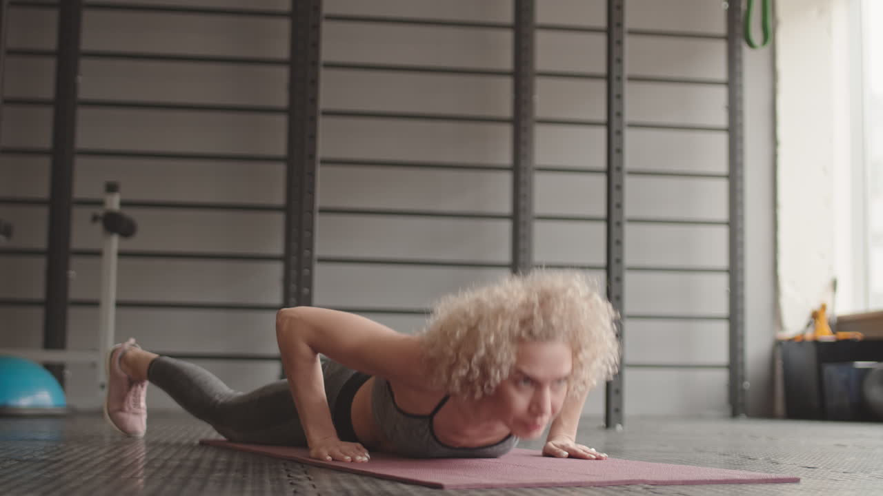 Woman Doing Burpees in Gym