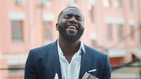 Joven-Empresario-Tirando-Dinero-Afuera.-Hombre-De-Negocios-Afro-Cantando-En-La-Calle