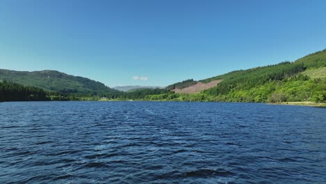 low drone flight over scottish loch near kinlochard, in the trossachs region of scotland on a sunny day