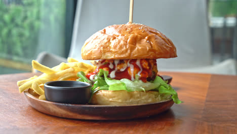 hamburguesa de ternera con queso y salsa en placa de madera