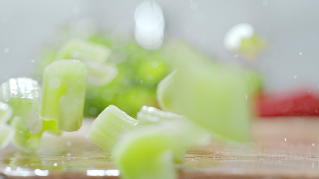 조각 된 셀러리 한 손가락이 부 카운터에 떨어지고, 거시 및 느린 동작으로 물방울을 습니다.