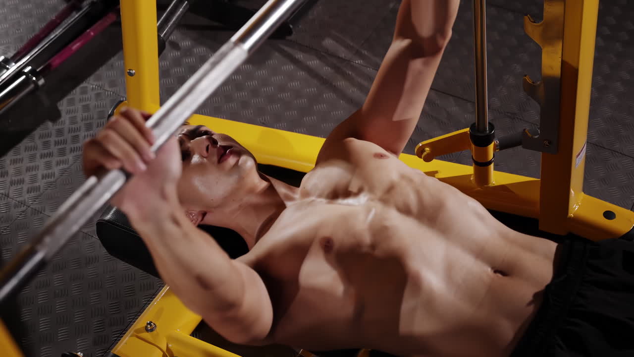 Atleta sportivo forte e muscoloso, con addominali scolpiti, che solleva pesi con un bilanciere pesante, praticando lo strappo con i muscoli della schiena tesi in palestra, mostrando potenza, forza e determinazione nell'allenamento.