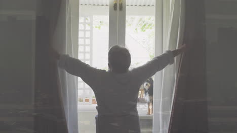 opening curtains, person welcoming sunlight into bright room with garden view