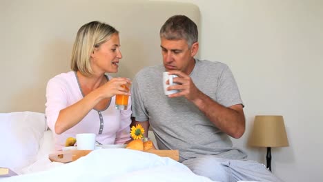 Wife-enjoying-breakfast-in-bed-brought-by-husband