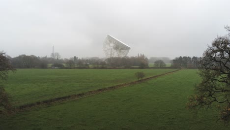 antena jodrell bank observatory lovell telescopio elevándose sobre brumoso paisaje rural