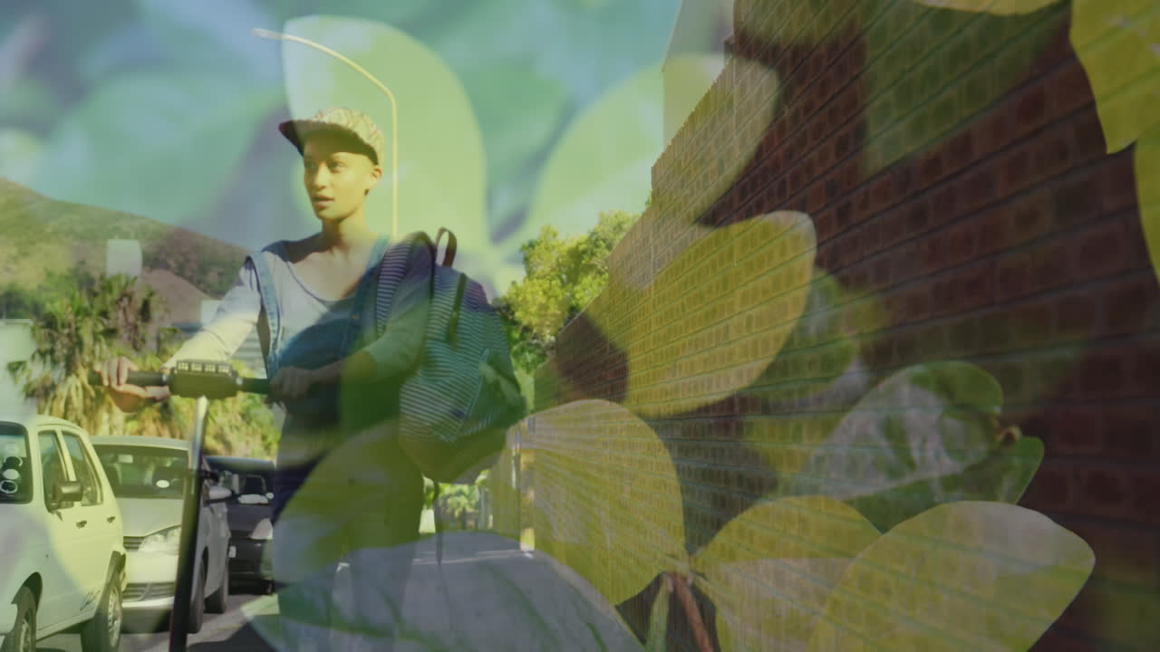 анимация листьев над двухрасовой женщиной, идущей с скутером по улице.