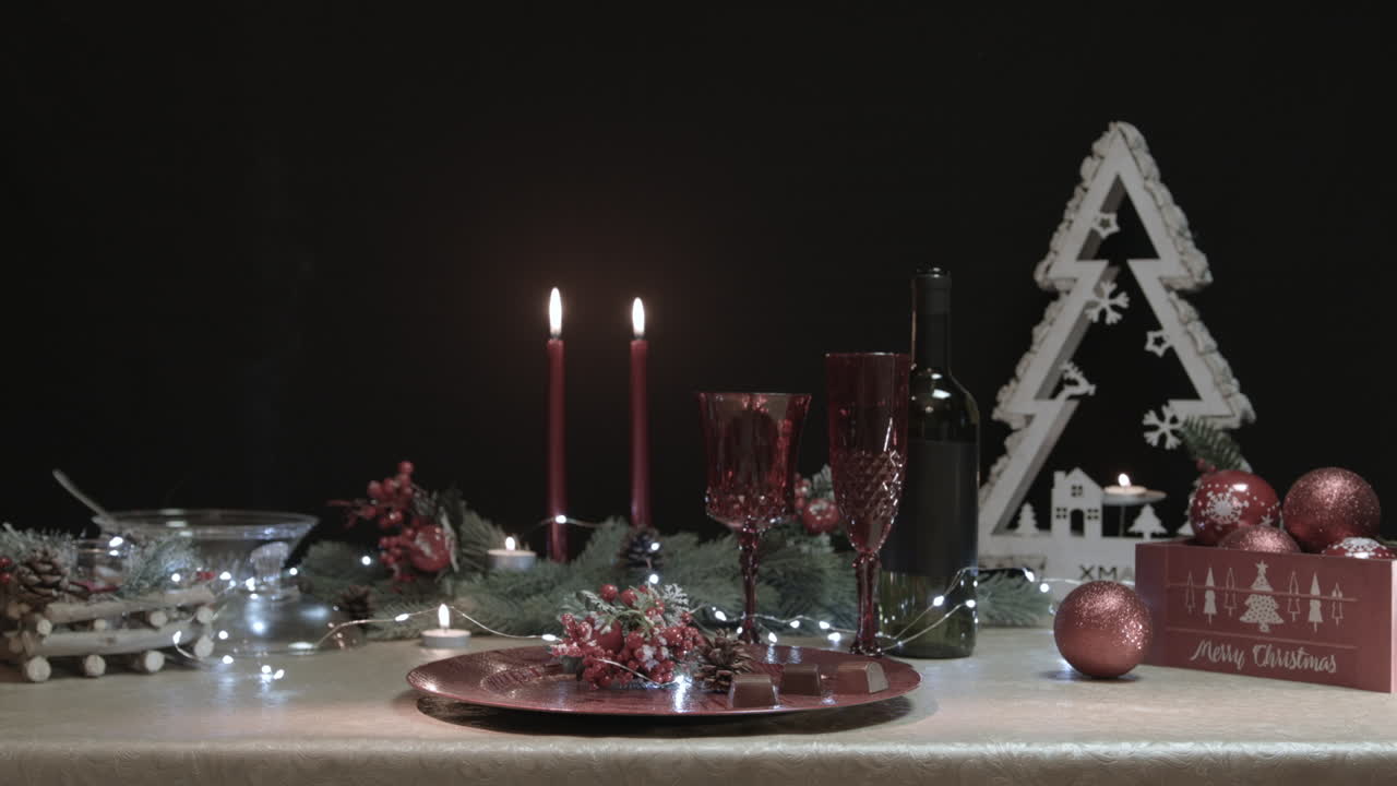 el hombre roba dos chocolates de una mesa de navidad decorada en una habitación oscura