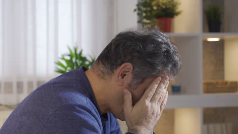 mature man with severe headache massaging head with hands.