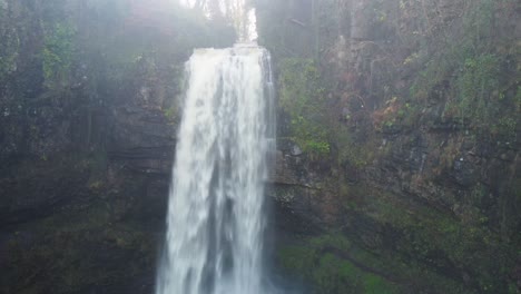 großer, schneller wasserfall aus rauem fluss mit klippe in wales, großbritannien - luftdrohnenaufnahme 4k