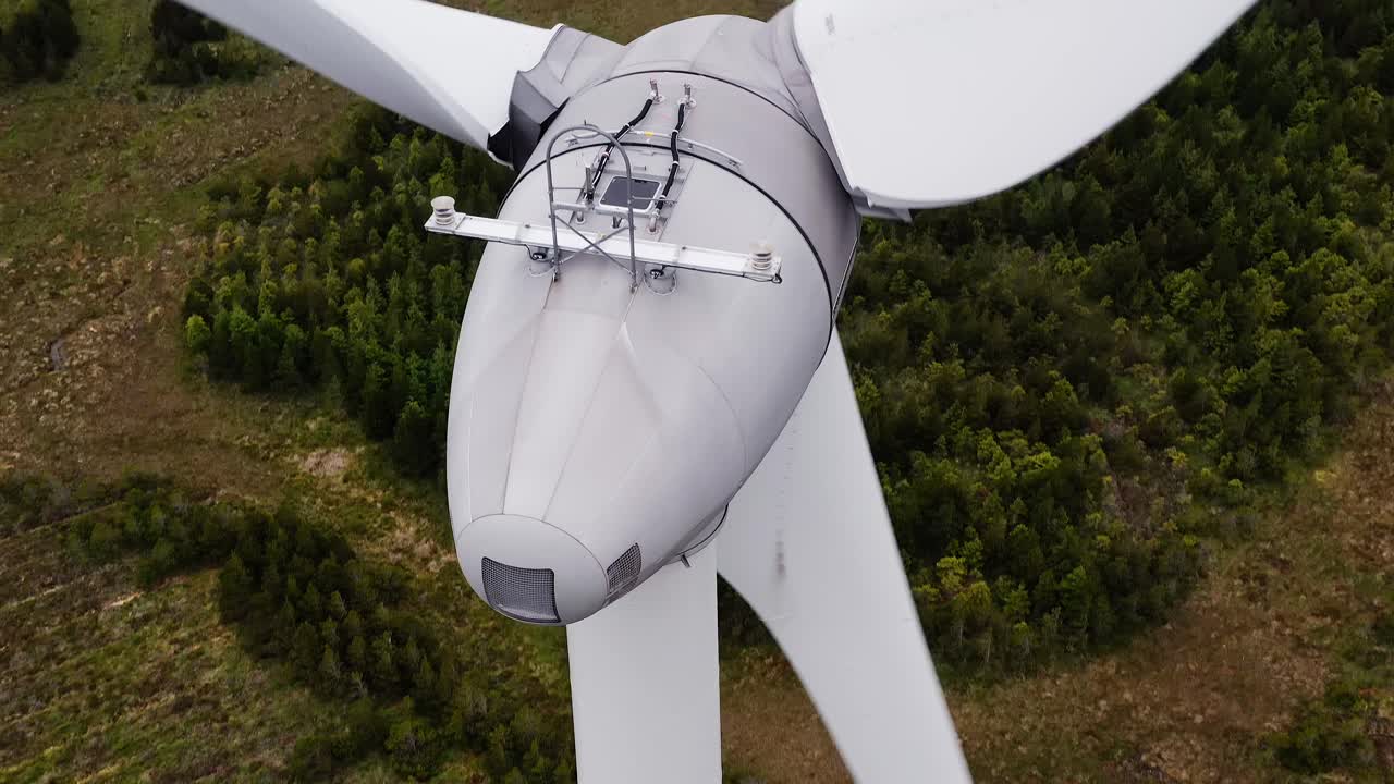 Close up drone shot of the blade mechanism at the top of a wind turbine