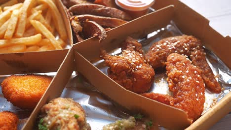 fried chicken, fries, and nuggets combo in a box