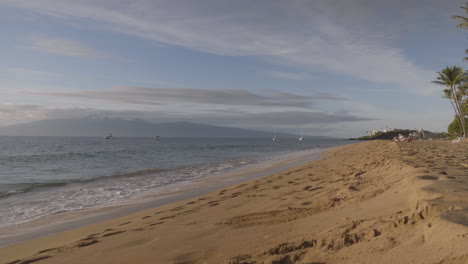 ocean waves splashing on the sandy shore at the beach in maui, hawaii