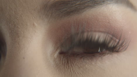 closeup of woman eye wearing augen contact lens with long salon lashes, natural eye and face makeup