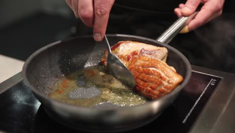 chef cooking meat in a pan