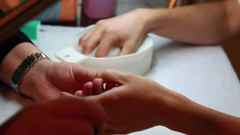 técnico de uñas dando a un cliente una manicura