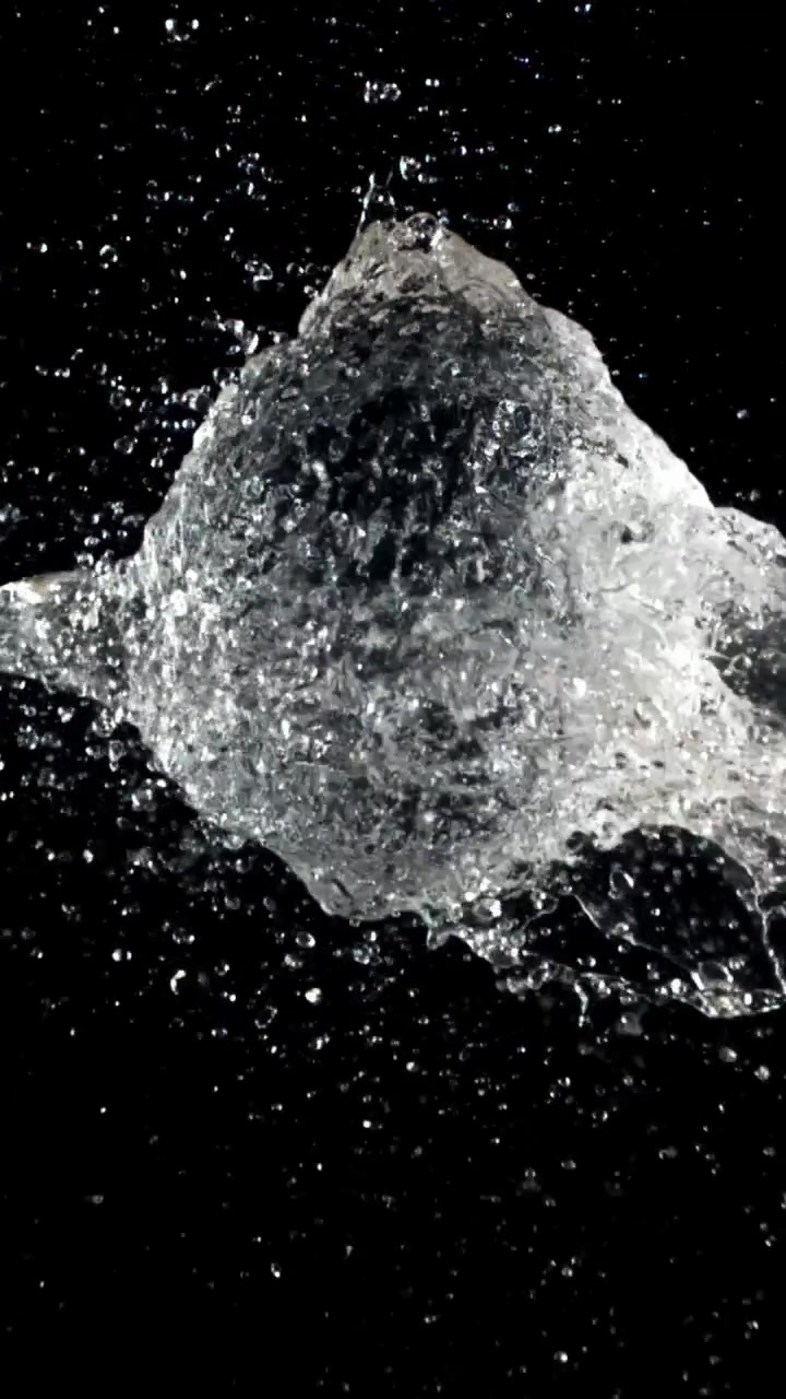 Slow Motion Water Balloon Bursting and Splashing on Black Background
