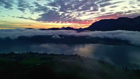 Panoramablick-Auf-Niedrige-Wolken,-Die-über-Dem-See-Hängen,-Berge-Im-Hintergrund-Und-Makrelenhimmel-Bei-Sonnenuntergang