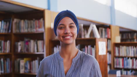 Asian-female-student-wearing-a-blue-hijab-looking-at-camera-and-smiling