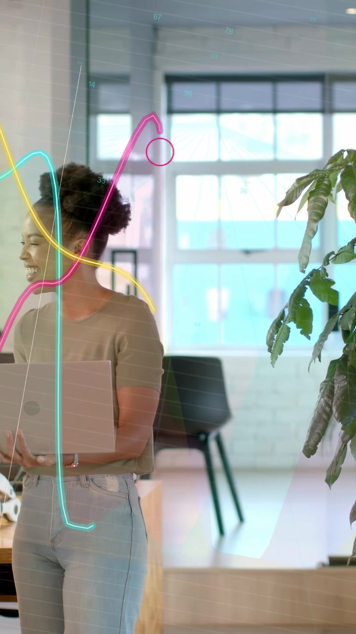 Vertical video: Woman with laptop smiling at cue while graphs flowing over her showing tech data