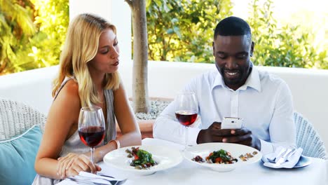 man ignoring bored woman while using mobile phone