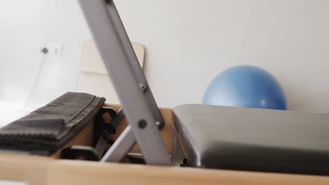 close up of empty pilates rehabilitation room with reformer and exercise balls, slow motion