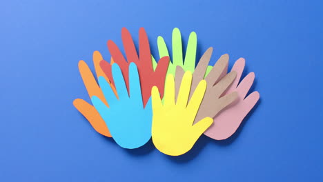 cerca de las manos juntas hechas de papel de colores sobre fondo azul con espacio para copiar