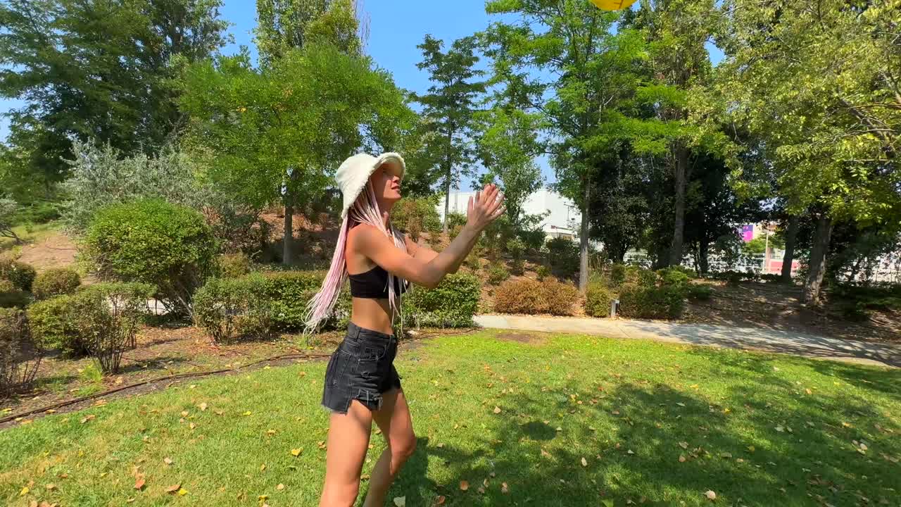 Women playing with a yellow ball in a park