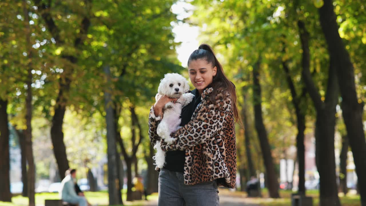 가을 공원에서 말테스 개와 함께 젊은 여성