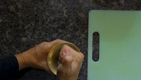 woman smashing garlics with salt in a mortar