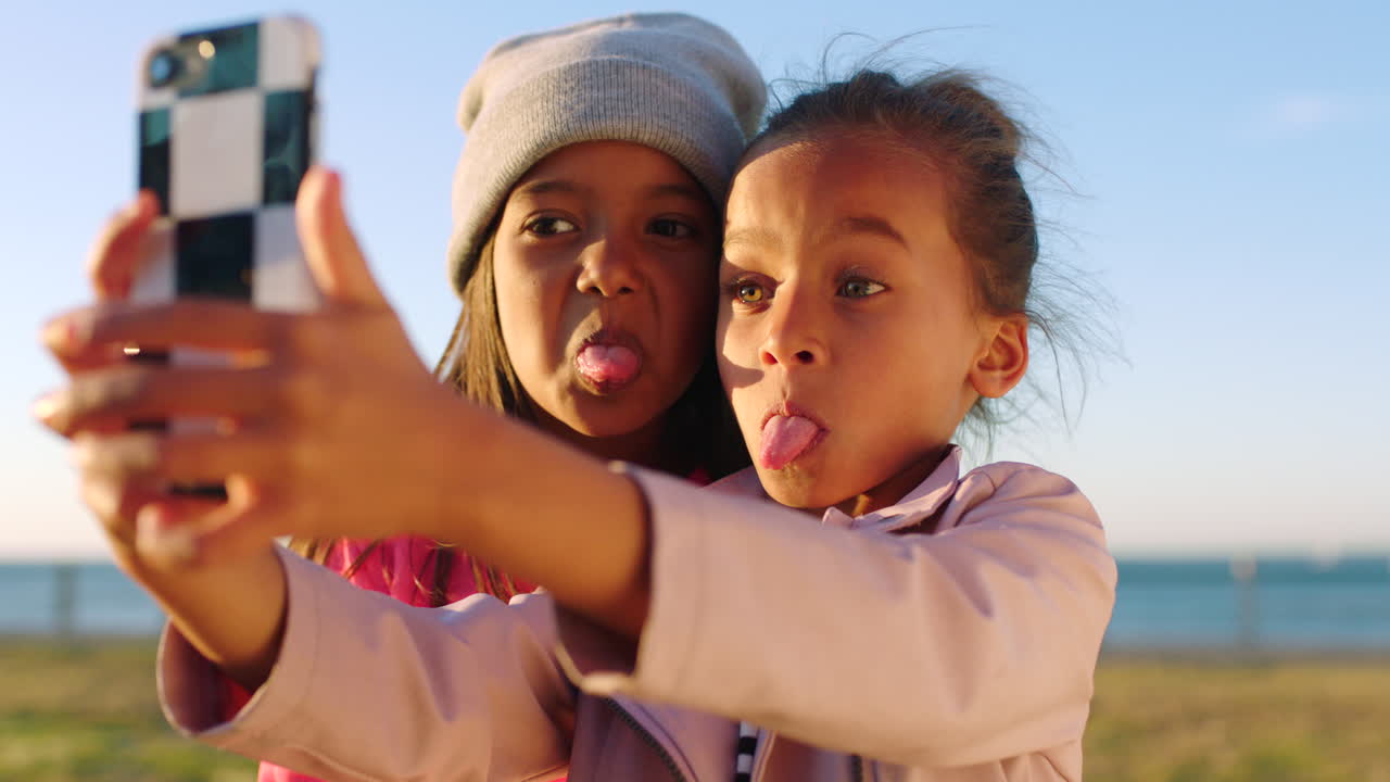 niños, amigos y teléfono selfie en el parque de la playa