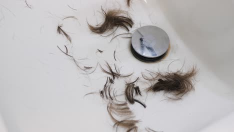 Slow-motion-video-of-hair-falling-into-a-white-sink