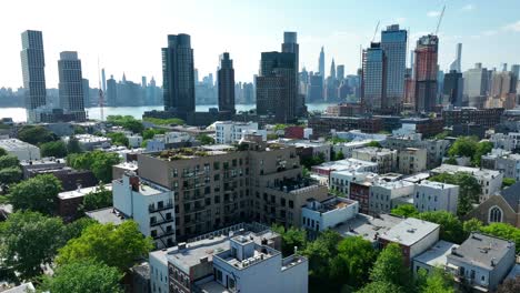 Barrio-De-Sobrevuelo-Aéreo-En-Brooklyn-Con-Río-Y-Horizonte-En-Manhattan-En-El-Fondo---Plano-Panorámico-Amplio