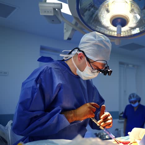 surgical process in the operating theatre. professional surgeon conduct an operation using surgical tools. nurse assists a doctor in modern hospital