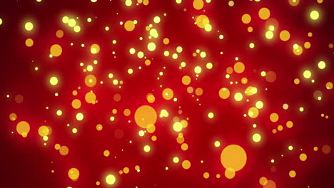 glowing yellow christmas light particles and orange bokeh lights moving across red bokeh background