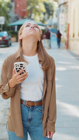 upset young woman using smartphone loses becoming surprised sudden lottery results on city street