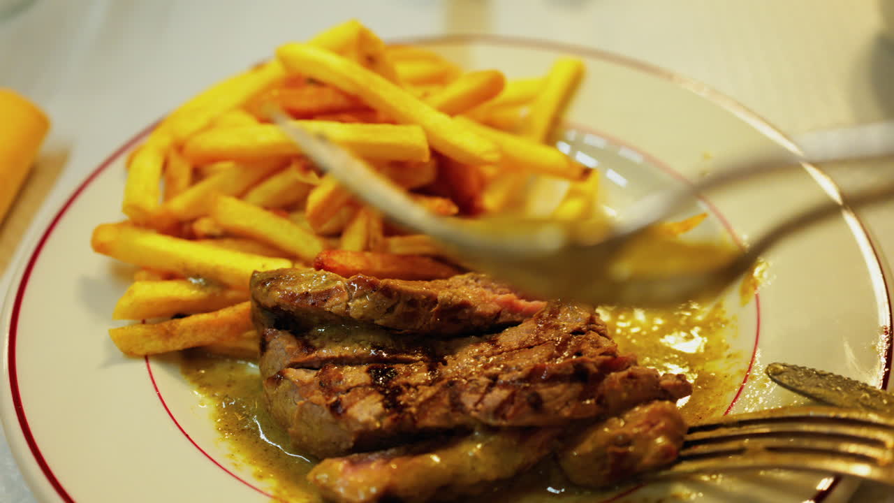 Close up of a plate of fries with meat and green sauce on a plate